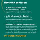 Natürlich genießen. WIR WERDEN GESÜNDER! Text über ausgewogene Ernährung und Wohlbefinden auf grünem Hintergrund.