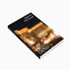 Buchcover mit den Texten: "Marie NDiaye", "DER GUTE DENIS", "Suhrkamp". Hintergrund zeigt unscharfe Lichter.