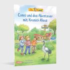 "Conni und das Abenteuer mit Kranich Klaus". Drei Kinder mit einem Kranich vor einem Spielplatz mit einem Spielschiff.