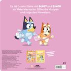 Text: "BLUEY", "HURRA, ES IST OSTERN!", "MIT KLAPPEN". Zwei Hunde in einer Küche mit Osterdekor.
