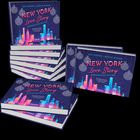 Buchstapel mit Titel "New York Love Story: Weihnachten mit dir". Bunte Skyline und Weihnachtskugeln auf dem Cover.