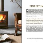 Text: "EINLEITUNG. Jeder, der die richtige Immobilie und den richtigen Standort hat, kann einen Holzofen einbauen."

Beschreibung: Ein Holzofen mit brennendem Feuer, daneben ein Ledersessel und ein offenes Buch auf einem Teppich.