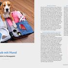 Musterlayout. Gut zu Wissen. Urlaub mit Hund. Das gehört ins Reisegepäck. Ein Hund sitzt auf einem offenen Koffer voller Kleidung.
