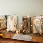 Vier Bücher mit gefalteten Seiten zeigen die Buchstaben "TERMS", umgeben von Lichterketten.