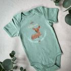 Text: "Hello little one". Illustration: Ein Rehkitz sitzt, umgeben von Blättern, auf einem grünen Babystrampler.