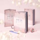 "FOUND family" und "MEINE FREUNDINNEN UND FREUNDE" sind auf rosafarbenen Büchern mit floralen Verzierungen.