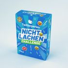 "Twitterperlen NICHT LACHEN CHALLENGE" steht auf einer blauen Verpackung mit Emojis und dem riva-Logo.