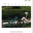 Text im Kalender: Mai, Juni, 22. Woche. Zitat: "An der Startlinie sind wir alle Philosophen." Fahrrad und Person im Grünen.