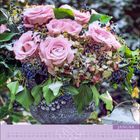 Januar. Rosa Rosen in grauer Vase, Schnee und Beeren; unten Kalender mit Daten.
