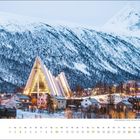 "januar" und Kalendarium. Eine moderne, beleuchtete Kirche vor schneebedeckten Bergen und winterlicher Stadtlandschaft.