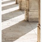 Der Text "JANUAR" steht oben. Unten: Kalendertage und -zahlen. Sonnenlicht fällt auf Säulen und Boden.