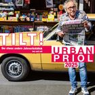 "TILT! Der etwas andere Jahresrückblick von und mit URBAN PRIOL 2025". Ein Mann in Jeans hält eine Zeitung vor einem gelben Auto.