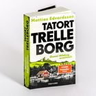 Buchtitel „Tatort Trelleborg“ von Mattias Edvardsson. Graues Bild mit rotem Haus an einem See.