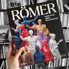 "Römisches Reich, Gesichter eines Weltreiches. Begleitbuch zur Ausstellung. Logo oben, Buchbeschreibung unten."