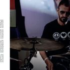 Links Text über Schlagzeug spielen, Kindheit und Inspiration. Rechts ein Mann in dunklem T-Shirt mit Schlagzeug spielend.