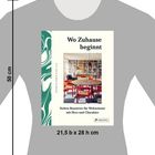 "Wo Zuhause beginnt" in großen Buchstaben. Darunter eine gemütliche Bibliothek mit rotem Tisch und Stühlen.