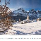 1. Januar 2024. Eine verschneite Landschaft mit Bergen, Kirche, Bäumen und einem klaren Himmel im Hintergrund.