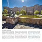 Die Goethe Universität. Skulptur sitzt vor einem Teich, dahinter ein großes Gebäude und Bäume unter klarem Himmel.