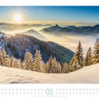 "01" und Datumszahlen unten. Winterlandschaft mit schneebedeckten Bäumen, Bergen und aufgehender Sonne im Hintergrund.
