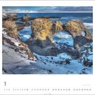 Text: "Küste vor Arnarstapi, Snæfellsnes | Foto: Josef Schäfer". 
Schneebedeckte, felsige Küstenlandschaft mit natürlichem Steinbogen.