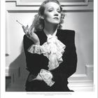 Text: "Marlene Dietrich. Deutsche Schauspielerin und Sängerin mit markanter Stimme..."

Eine Frau mit Zigarette, elegant gekleidet.