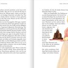 DRITTE STROPHE, DER ZWEITE GEIST. Eine Frau in traditionellem Kleid hält stolz einen Pudding auf einem Tablett.