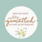 "Mach es dir so richtig gemütlich - du hast es dir verdient." Verziert mit Blumen-Illustrationen auf grünem Hintergrund.