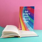 Buch "Die Kraft des Trotzdem" von Tilmann Haberer, buntes Design, daneben geöffnetes Buch auf pink-türkisem Hintergrund.