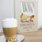 Cover-Text: "Wunder ErWarten: Texte, Bilder und Gebete, die das Schöne suchen." Vordergrund: Cappuccino, Keks.