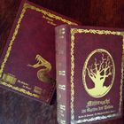 "Mitternacht im Garten der Totes" prangt auf Buchcover. Goldene Verzierungen, links Schlange, rechts Baum im ovalen Rahmen.