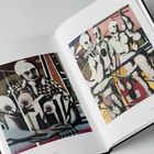 Links: "2014", "129 x 105 cm". Gemälde abstrakter Figuren mit geometrischen Formen und maskenhaften Gesichtern.