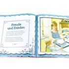 "Freude und Frieden" steht auf der linken Seite, mit Text über Gottes Gaben. Rechts ein Bild mit zwei Mädchen beim Tischdecken.