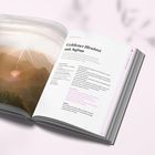 Rezept für "Goldener Hirsebrei mit Safran" in einem offenen Buch. Links ein Bild von Bergen bei Sonnenaufgang.