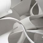 Keine Texte. Abstrakte Anordnung von geschwungenen, weißen Papierbögen in einer komplexen, skulpturalen Form.