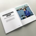 Text: "FOTOGRAFISCHES ARCHIV IKONOGRAFIE EINER HAMBURGER KÜNSTLERFIGUR." Rechts ein Foto einer Person am Wasser.