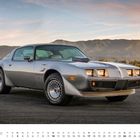 "JANUAR" steht unten links, Kalenderdarstellung darunter. Ein silberner Pontiac Trans Am steht auf einer Straße vor Bergen.