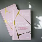 Zwei rosafarbene Bücher mit dem Titel "Adieu, Ella" von Elke Rutenhöfer liegen auf einem Tisch.