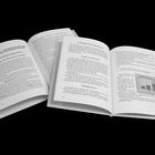 Zwei aufgeschlagene Bücher. Links: Kapitel 7 mit Überschrift zur Einfachheit. Rechts: Text über Dummheit und ein Diagramm.