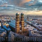 "Frauenkirche im Winter." Kalender: Zahlen und Wochentage unten. Schneebedecktes Stadtdach und Kirche bei Sonnenaufgang.