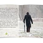 „Guten Tag“, grüßte er den erblassten Mann. Der Mann im Mantel geht im Schnee mit Regenschirm, Rückenansicht.