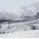Kalenderblatt für Januar. Dampflokomotive im Schneegestöber fährt durch eine verschneite Landschaft.
