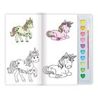 Malbuch mit vier Einhörnern, zwei farbig, zwei schwarz-weiß; daneben bunte Herz-Aquarellfarben und Pinsel.