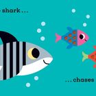 „This little shark… chases scaly fish.” Ein lächelnder Hai und bunte Fische in einer einfachen Illustration.