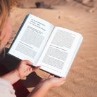 Ein Buch wird in der Sonne gelesen, die Seiten zeigen Texte über Führung und digitale Transformation.