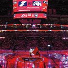 Anzeige: "Us Amerant Bank". Eishockeyarena, Spielfeld beleuchtet, Zuschauer und Bildschirme zeigen Informationen.