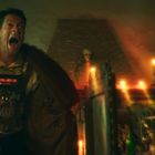 Ein aufgeregter Mann mit Timer auf der Brust (05:47:11) in einem düsteren Raum voller Kerzen und mystischer Dekorationen.