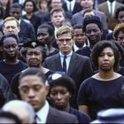 Menschenmenge bei einer Gedenkveranstaltung, mehrheitlich in schwarzer Kleidung, zeigt ernste Gesichtsausdrücke.