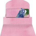 Ein geöffneter rosa Briefumschlag mit einem 20-Euro-Schein und einer grünen Karte darin.
