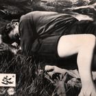 Text: "Im Feuer der Lust". Eine Person liegt im Gras, scheinbar ausgestreckt und entspannt.