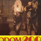 Text: "SODOM 2000". Eine Gruppe von Menschen in bunten, verlebten Kleidern, ein Baby wird gehalten.